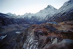 201 Annapurna Base Camp Before Sunrise - Annapurna III,  Gabelhorn, Machapuchare Annapurna Sanctuary Base Camp is a collection of stone huts surrounded by mountains and glaciers at around 4130m. This was the site of Chris Bonington�s Base Camp for the 1970 British expedition that completed the first ascent of the Annapurna South Face. I was up early and walked in the -1C clear weather for ten minutes to the monument hill. Before the sun started rising, I looked back to the east of Annapurna Sanctuary Base Camp to see the ridge connecting Annapurna III (7555m) to Gandharva Chuli (Gabelhorn, 6248m) to Machapuchare (6993m).